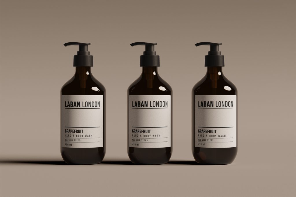 Three bottles of Laban London grapefruit hand and body wash on a warm taupe background